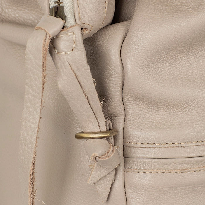 Close-up of a beige leather bag with stitching details