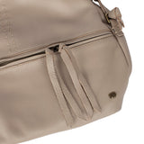 Close-up of a beige handbag with a visible brand logo on a white background