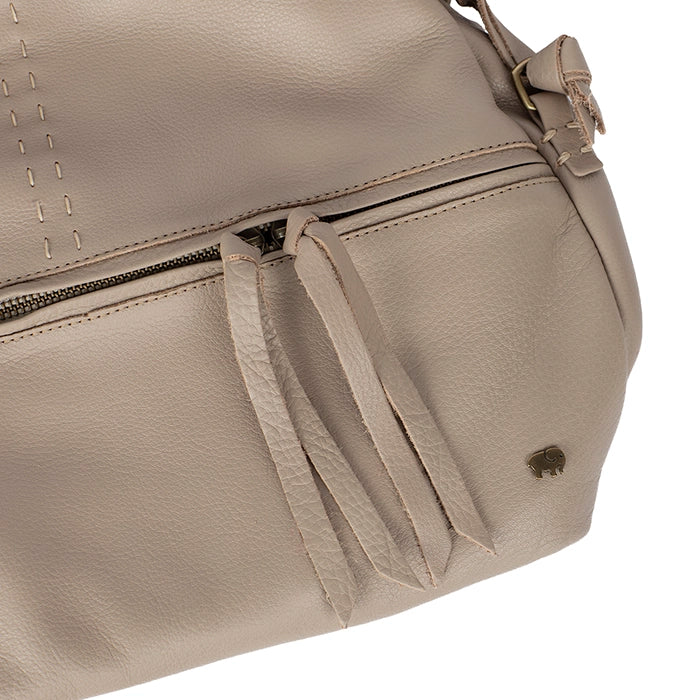 Close-up of a beige handbag with a visible brand logo on a white background